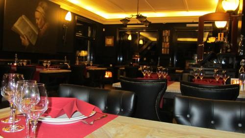 a restaurant with a table and chairs and wine glasses at Hotel het Rietershuijs in Kalenberg