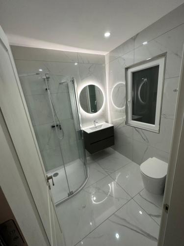 a bathroom with a shower and a toilet and a sink at ONE100 apartments in Marsaxlokk