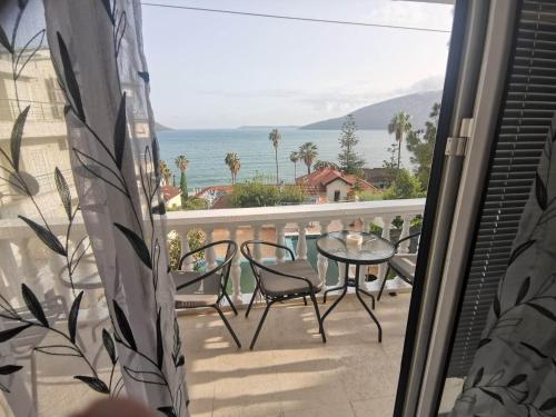 a balcony with a table and chairs and a view of the ocean at Petrovic house in Herceg-Novi