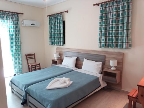 a bedroom with a bed with two white towels on it at Panagiotis I & II Stds and Apts in Tsilivi