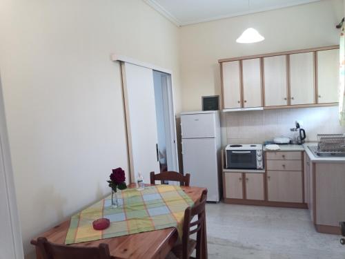 a kitchen with a table and a kitchen with a refrigerator at Panagiotis I & II Stds and Apts in Tsilivi