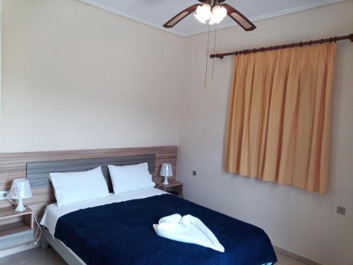 a bedroom with a large bed with a blue blanket at Panagiotis I & II Stds and Apts in Tsilivi