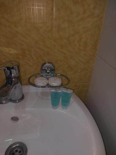 a white toilet with two cups on top of it at Sweet home in Tbilisi City