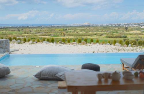 una grande piscina con vista su una spiaggia di Vouno Luxury Villas a Glinado Naxos