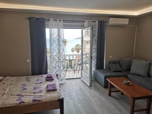 a living room with a bed and a couch and a balcony at Petrovic house in Herceg-Novi