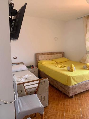 a bedroom with a bed and a chair and a television at Sulaj Sea View 1 in Himare