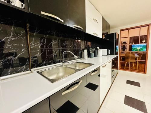 a kitchen with a sink and black and white tiles at Arshakunyats 88 TopHouse in Yerevan