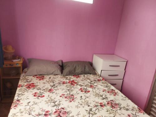 a small bedroom with a bed and a dresser at Casa inteira com AR 2/4 in Salvador