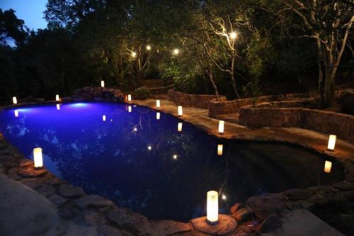 una piscina por la noche con velas en Waterberg Hideaway, en Thabazimbi