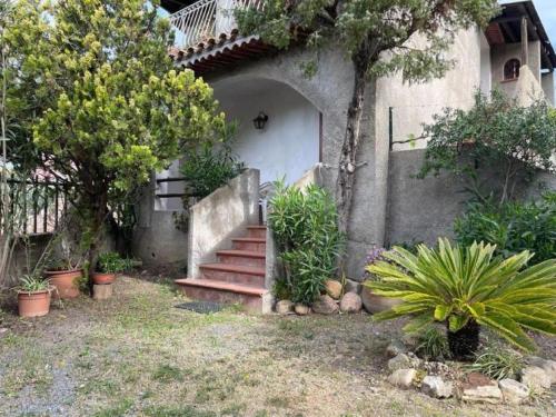 a house with stairs and plants in front of it at Appartamenti Su Pasiu in Chia
