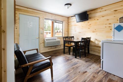 a dining room with a table and chairs and a refrigerator at Beargrass Lodging & RV Resort in Hungry Horse