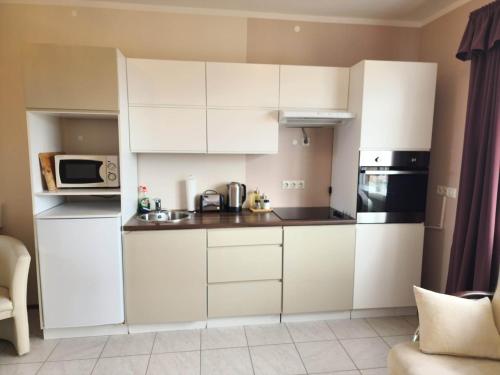 a kitchen with white cabinets and a microwave at Kiljan Apartments & Rooms in Blönduós