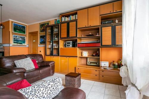 a living room with a leather couch and wooden cabinets at CASA AGATA A DUE PASSI DAL MARE in Santa Marinella