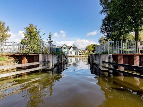a body of water with a house in the background at Holiday Home by Zuidlaardermeer Jetty in Kropswolde