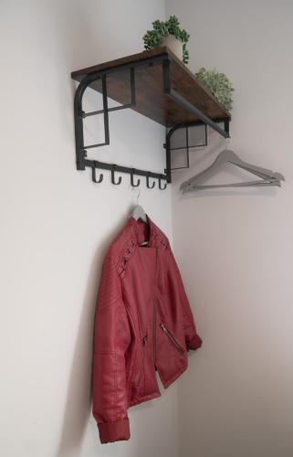 a red leather jacket hanging on a wall at 3 bedroom Cannock flat ideal for groups in Great Wyrley