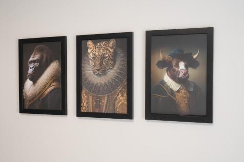 four framed pictures of animals on a wall at 3 bedroom Cannock flat ideal for groups in Great Wyrley
