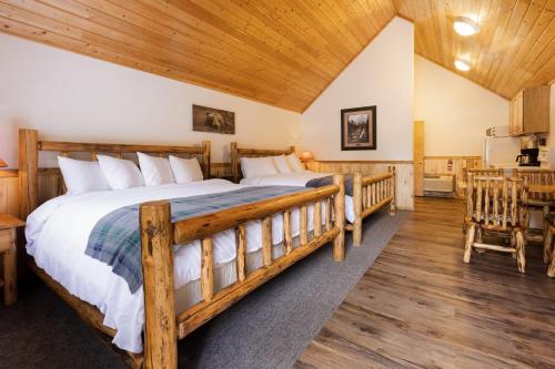 1 dormitorio con 1 cama grande y techo de madera en Beargrass Lodging & RV Resort en Hungry Horse