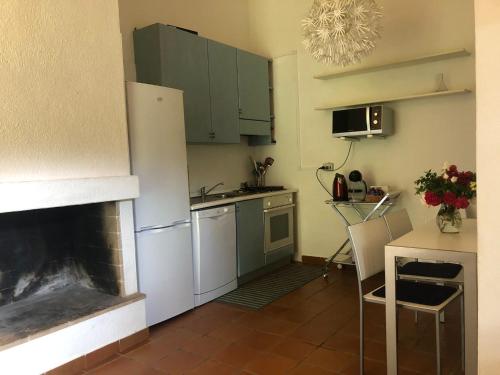ジェレメアスにあるVilla Flàの暖炉付きのキッチン、テーブル付きのキッチン