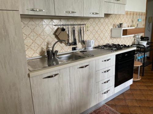 una cocina con fregadero y estufa en Casa Tino, en Murazzano