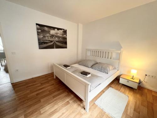 una camera con un letto bianco e una foto a parete di Apartment zentral in Duisburg 25 Min Messe Düsseldorf und Essen a Duisburg