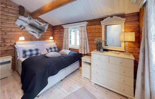 a bedroom with a bed and a dresser and a mirror at Stunning Home In Svingvoll With Jacuzzi, Sauna And 4 Bedrooms in Svingvoll
