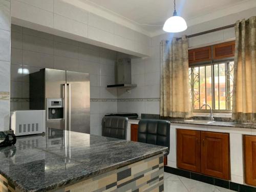 cocina con encimera y nevera en Luxury M Apartments en Kampala