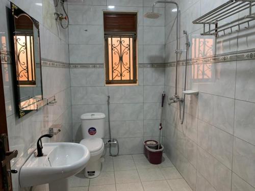 baño con lavabo y aseo y ventana en Luxury M Apartments en Kampala