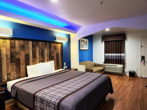 a hotel room with a bed and a chair at Express Inn Tomball in Tomball