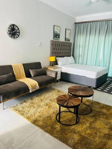 un soggiorno con divano e letto di Luxury Self Catering Studio - HoneyBee Apartment a Broadhurst