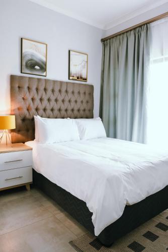 Luxury Self Catering Studio - HoneyBee Apartment في Broadhurst: غرفة نوم بسرير كبير ونافذة
