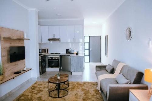 a living room with a couch and a table at Luxury Self Catering Studio - HoneyBee Apartment in Broadhurst