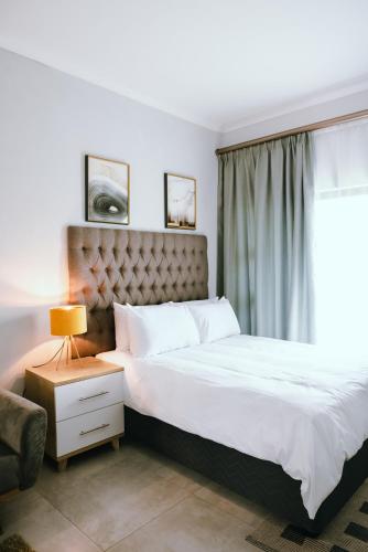 Luxury Self Catering Studio - HoneyBee Apartment في Broadhurst: غرفة نوم بسرير كبير ونافذة