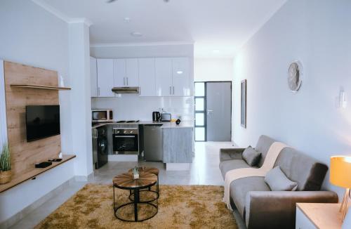Luxury Self Catering Studio - HoneyBee Apartment في Broadhurst: غرفة معيشة مع أريكة وطاولة