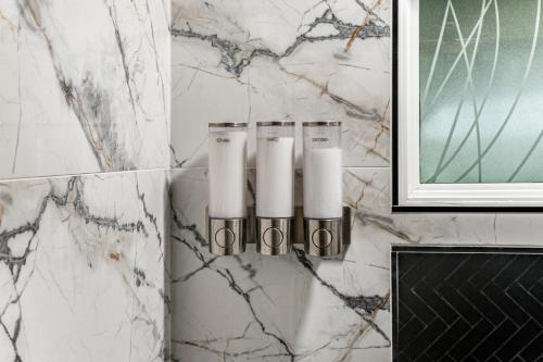 a bathroom with three candles on a marble wall at Pine Lodge Midtown Atlanta - Luxury Oasis, Quiet & Central Location, Beltline & Piedmont Park Steps Away in Atlanta