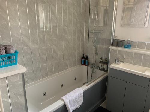 een badkamer met een douche, een bad en een wastafel bij Modern 2 bed apartment in Wallasey