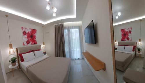 a hotel room with two beds and a television at Wide Blue Luxury Boutique Suites in Neos Marmaras