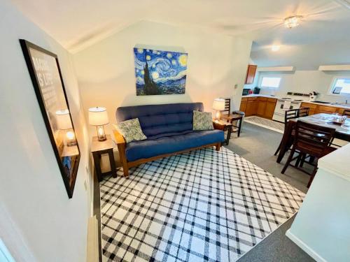 ein Wohnzimmer mit einem blauen Sofa und einer Küche in der Unterkunft Walk to the Outfield of Lime Rock Park in Salisbury