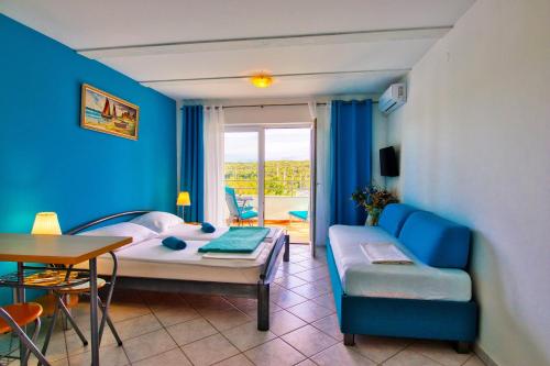 a living room with a bed and a couch and a table at Apartman Studio in Pula