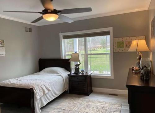 a bedroom with a bed with a ceiling fan and a window at Country home in Endwell