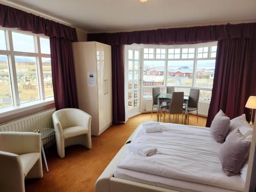 Habitación de hotel con cama, mesa y sillas en Kiljan Apartments & Rooms en Blönduós
