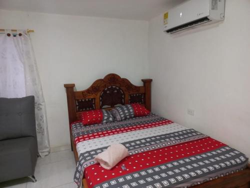 a bedroom with a bed with a red and white comforter at Hotel 7 in Cúcuta