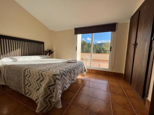 1 dormitorio con cama y ventana grande en Dúplex Río Madera, en Segura de la Sierra