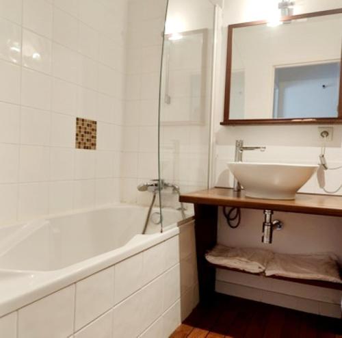 a bathroom with a white tub and a sink at Le Sea Breeze La Rochelle 44m2 - 2 chambres - 6 prs - Piscine in Lagord