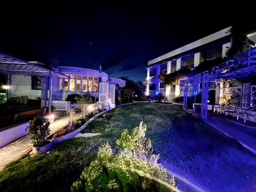 a building with a fountain in a yard at night at SCALA APARTS & STUDIOS - Rhodes in Afantou