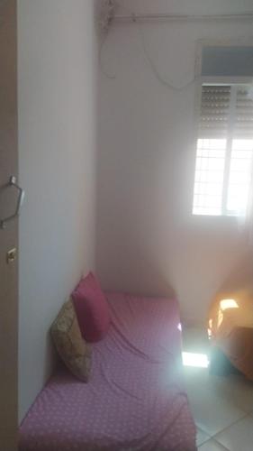 a small bed in a room with a window at appartement one room in Casablanca
