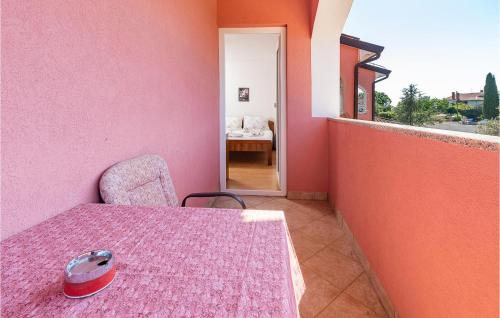 une table et une chaise dans une chambre avec un mur rose dans l'établissement Beautiful Apartment In Pavicini With Wifi, à Pavicini