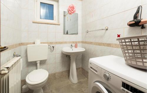 uma casa de banho branca com um WC e um lavatório em Beautiful Apartment In Pavicini With Wifi em Pavicini