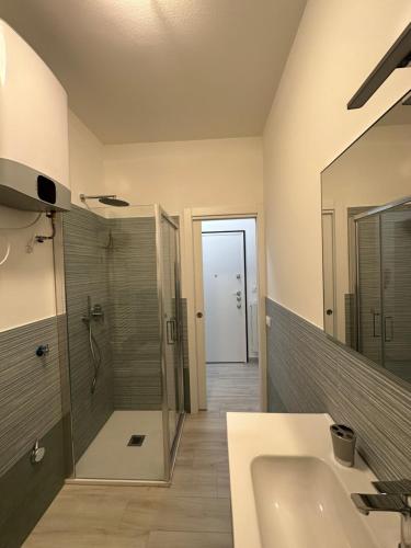 een badkamer met een douche, een wastafel en een spiegel bij La casa di Nonno Stefano in Loano
