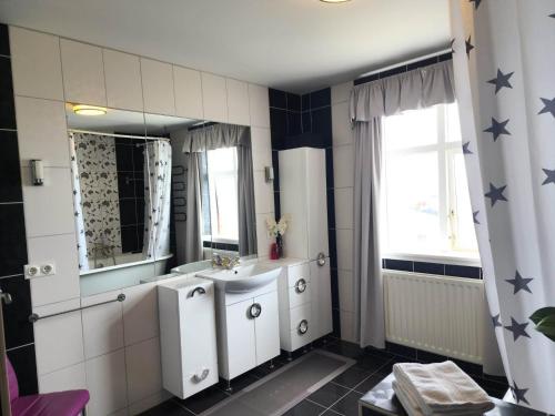 y baño con lavabo y espejo. en Kiljan Apartments & Rooms en Blönduós
