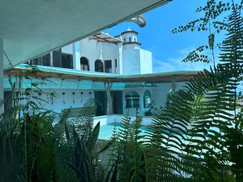 duży biały dom z mnóstwem roślin w obiekcie Isla vancouber w Acapulco